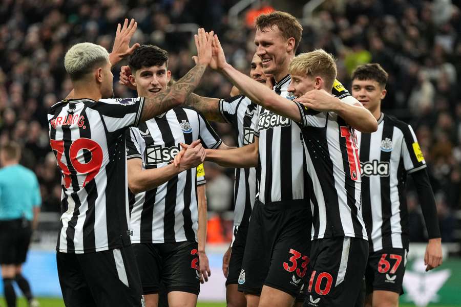 El defensa inglés del Newcastle United #33 Dan Burn (centro derecha) celebra con sus compañeros tras marcar el tercer gol.