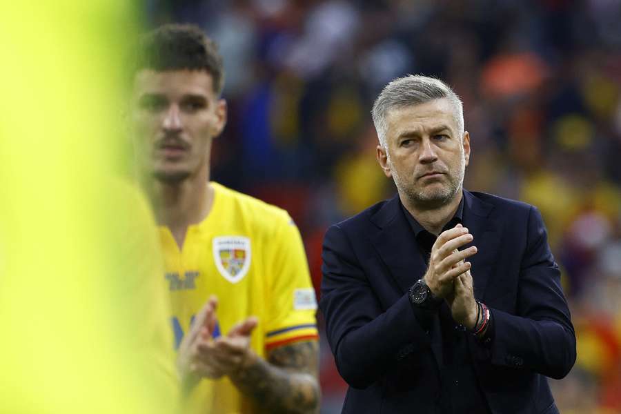 Romania coach Edward Iordanescu applauds fans after the match