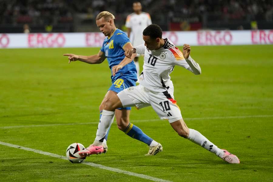 Ukraine's Mykhailo Mudryk (left) challenges for the ball with Germany's Jamal Musiala