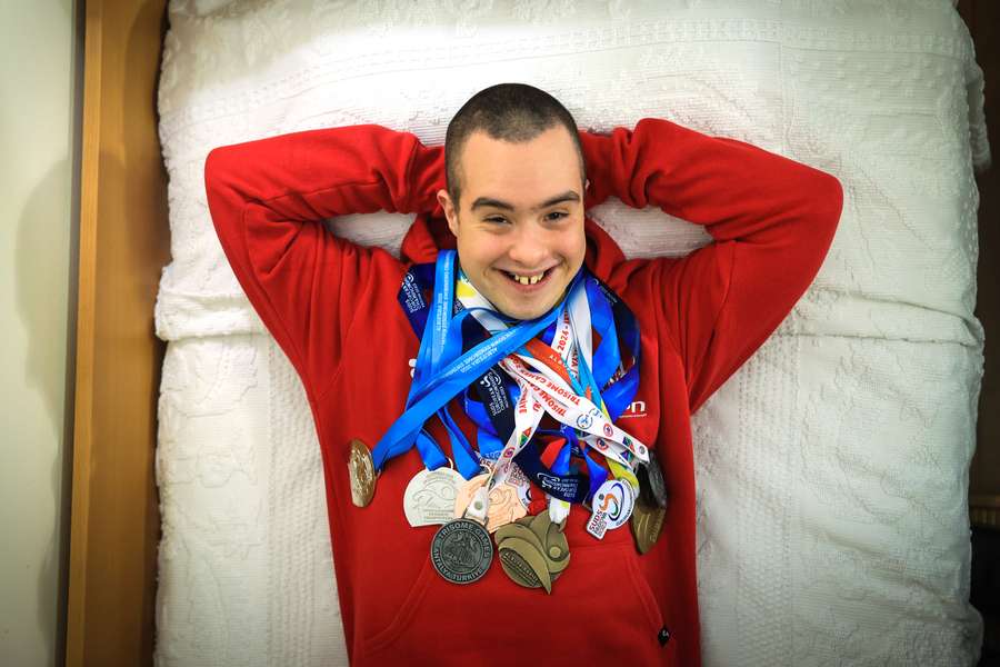 Vice-campeão do mundo de natação, Francisco Montes, de 24 anos e com trissomia 21, exibe algumas das medalhas conquistadas em sua casa no Porto