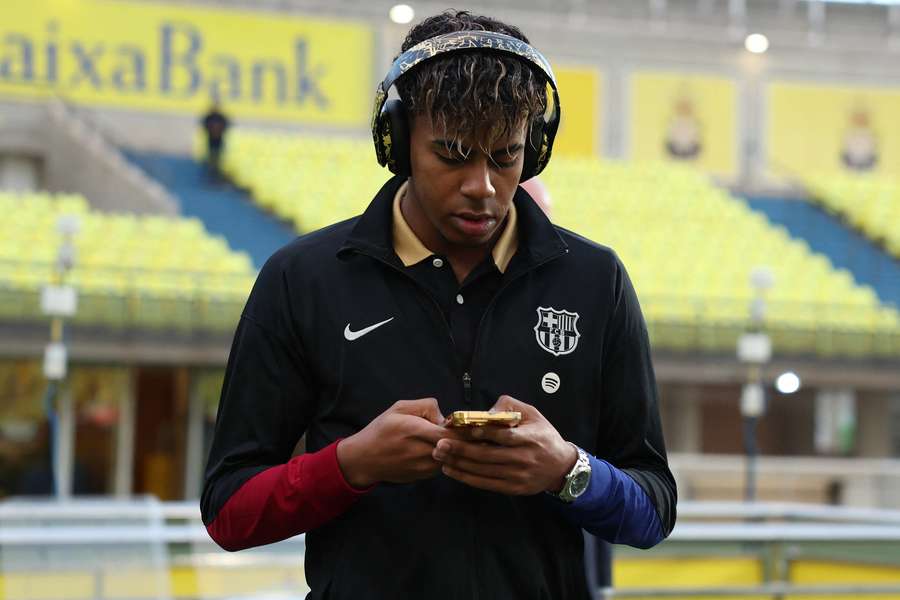 Lamine Yamal of FC Barcelona uses his mobile phone