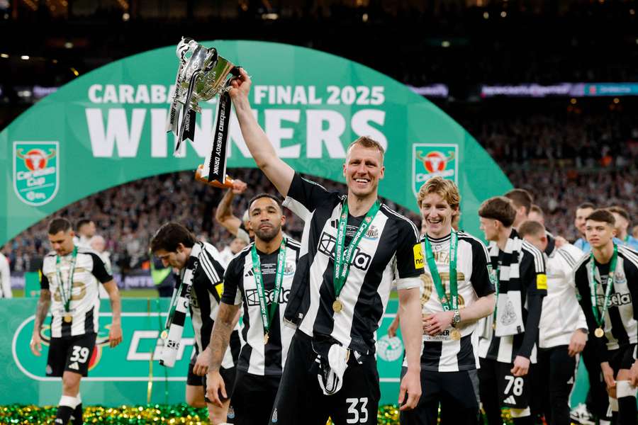 Newcastle United's Dan Burn celebrates with the trophy after winning the Carabao Cup