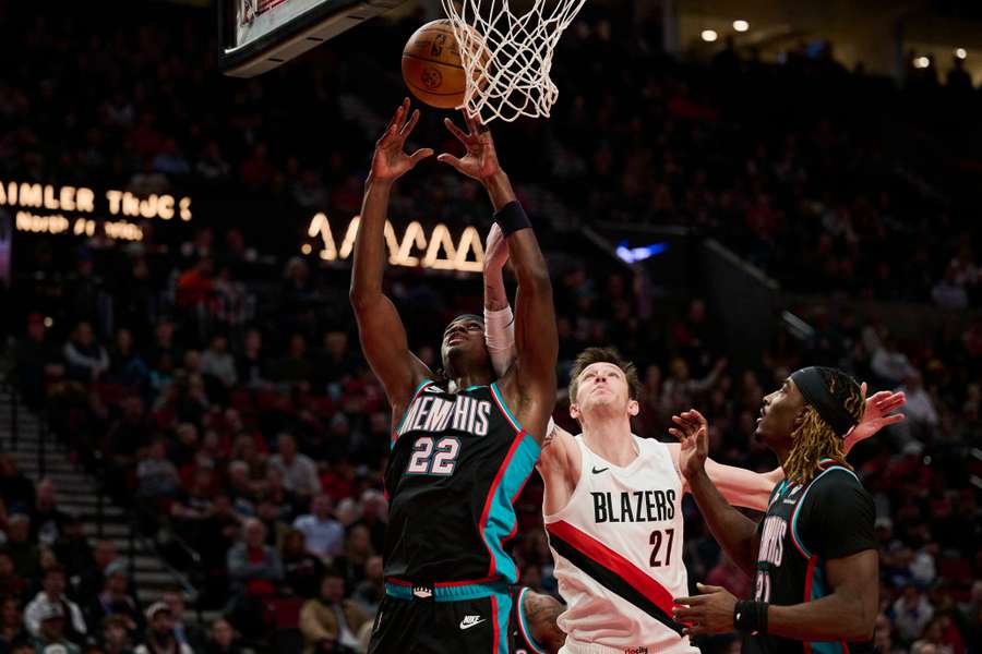 Vít Krejčí (v bílém) se snaží doskočit míč pod košem.