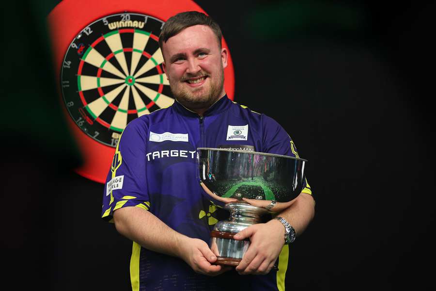 Luke Littler com o troféu do Grand Slam de Dardos