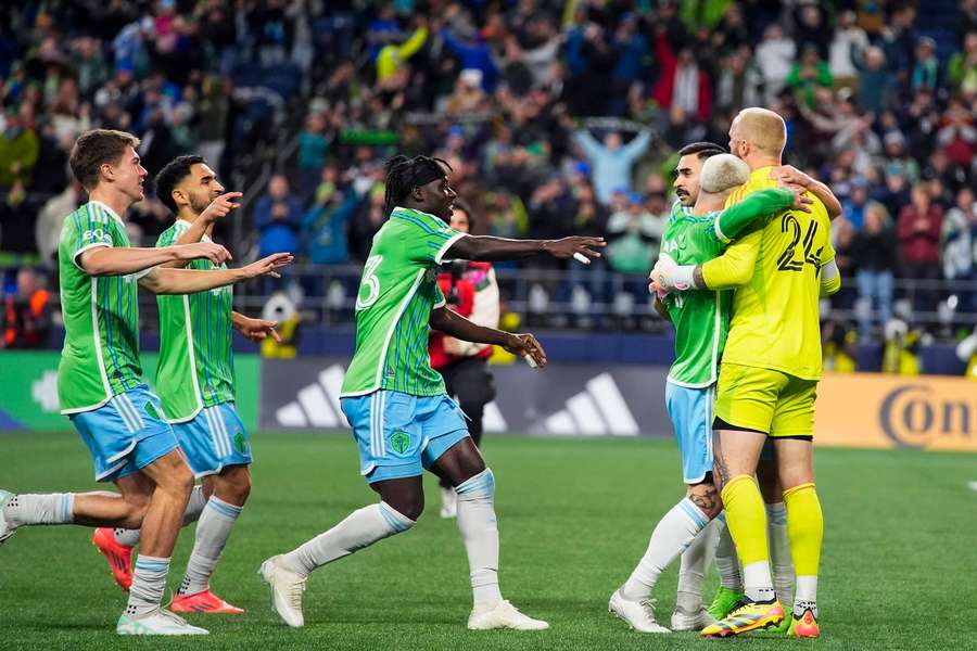 Spelers van Seattle omhelzen hun doelman na de gewonnen strafschoppenserie