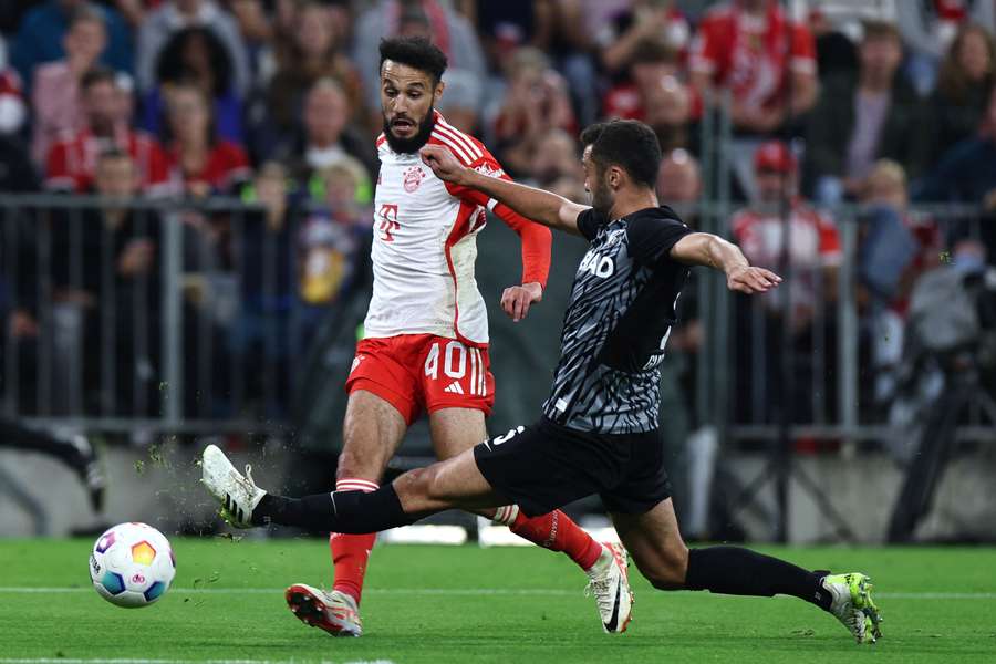 Noussair Mazraoui (L) in duel met Manuel Gulde (R) tijdens Bayern - SC Freiburg op 8 oktober 2023