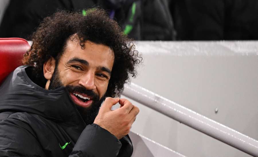 Liverpool's Egyptian striker #11 Mohamed Salah sits on the bench