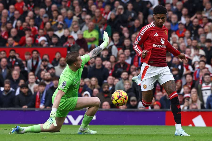 Manchester United's English striker #10 Marcus Rashford (R) takes the ball past Everton's English goalkeeper #01 Jordan Pickford 