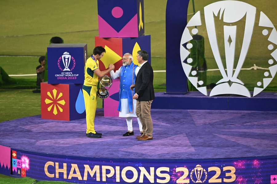 Australia's Pat Cummins is presented with the World Cup trophy