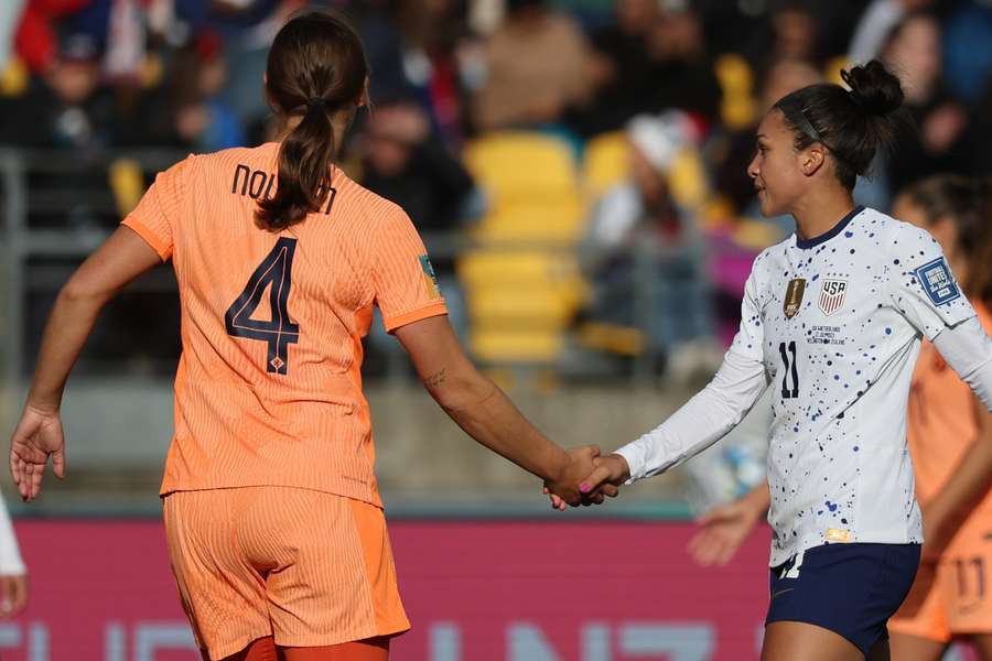 Netherlands' defender Aniek Nouwen (L) greets USA's forward Sophia Smith (R)