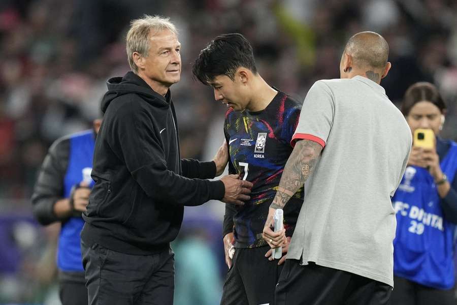 Son wird von Südkoreas Nationaltrainer Jürgen Klinsmann nach dem Aus im Halbfinale der Asienmeisterschaft getröstet.