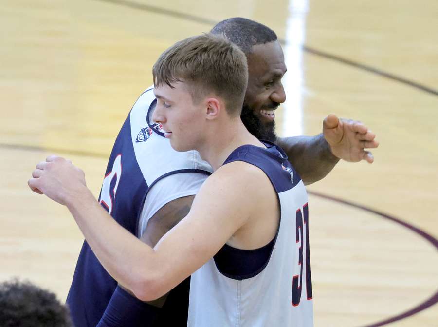 LeBron James (I) se abraza con Cooper Flagg (D).