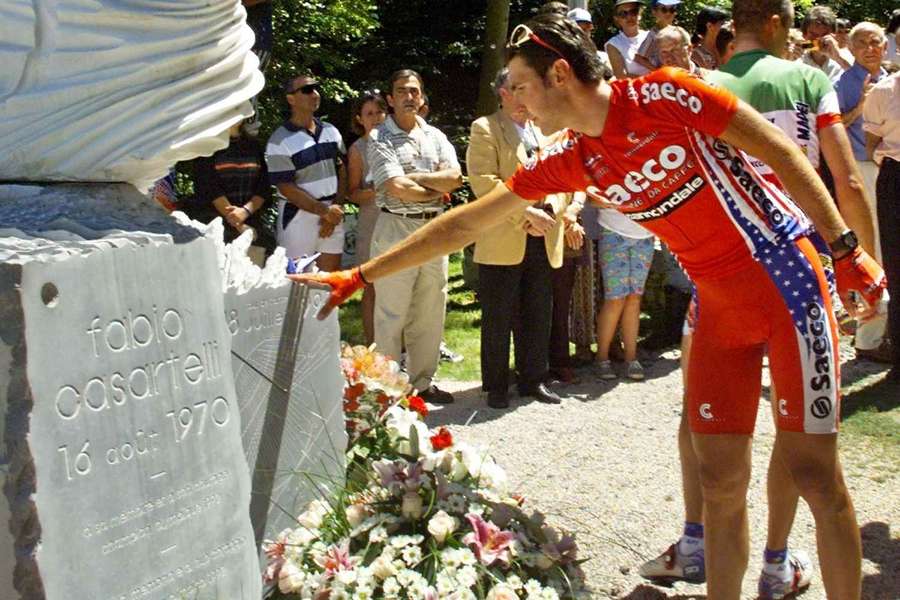 Un ciclista italiano toca el momnumento a Casartelli, en 1998