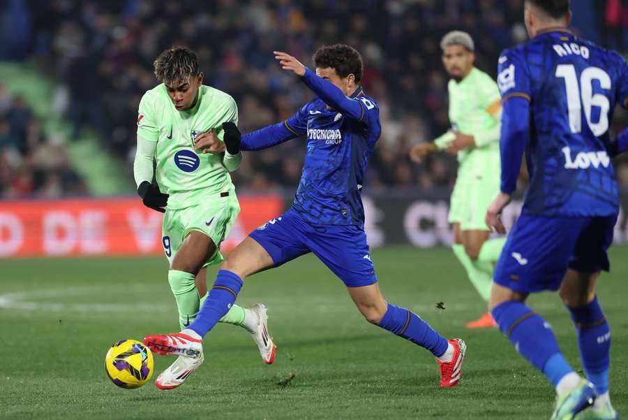 Barcelona's Lamine Yamal and Getafe's Luis Milla fight for the ball