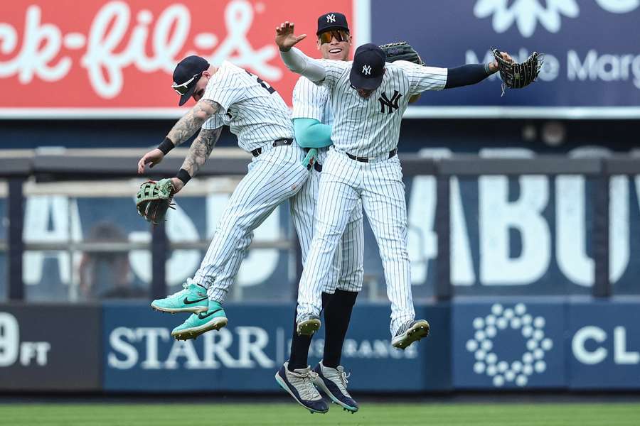 New York Yankees outfielders Alex Verdugo, Aaron Judge, and Juan Soto celebrate after defeating the Colorado Rockies at Yankee Stadium