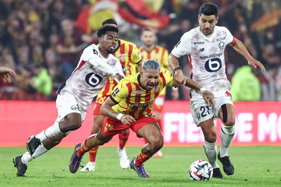 Facundo Medina vies with Lille's Angel Gomes, left, and Lille's midfielder Benjamin Andre