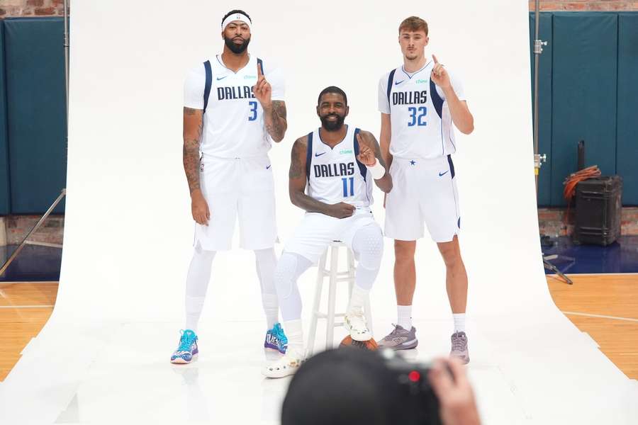 Kyrie Irving escoltado por Anthony Davis e Cooper Flagg