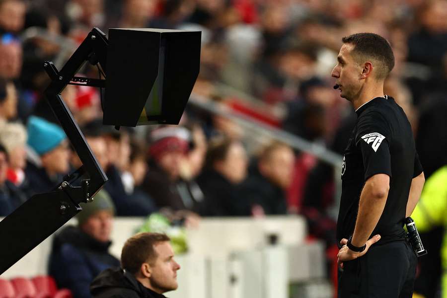 David Coote consults the pitch-side monitor during Brentford's game against Aston Villa in December