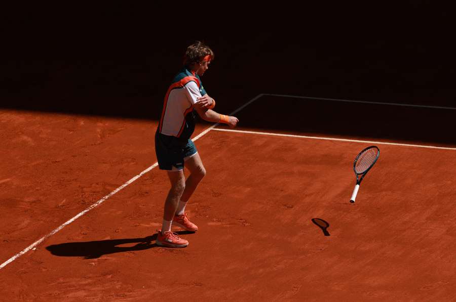 Andrey Rublev a atirar a raquete para o chão após a derrota