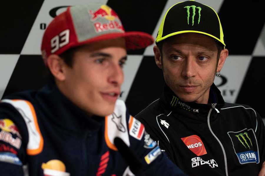 Valentino Rossi observa Marc Marquez numa conferência de imprensa