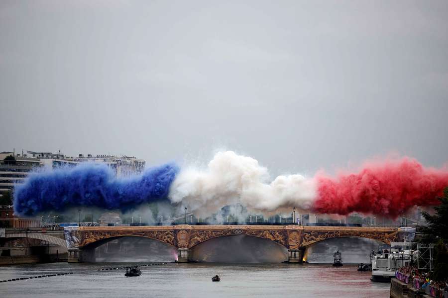 Nuvens de fumo com as tricolores da bandeira de França são vistas na Pont d'Austerlitz durante a cerimónia de abertura