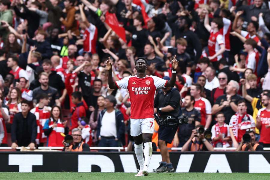 Arsenal's English midfielder #07 Bukayo Saka celebrates after his deflected shot makes it 1-0