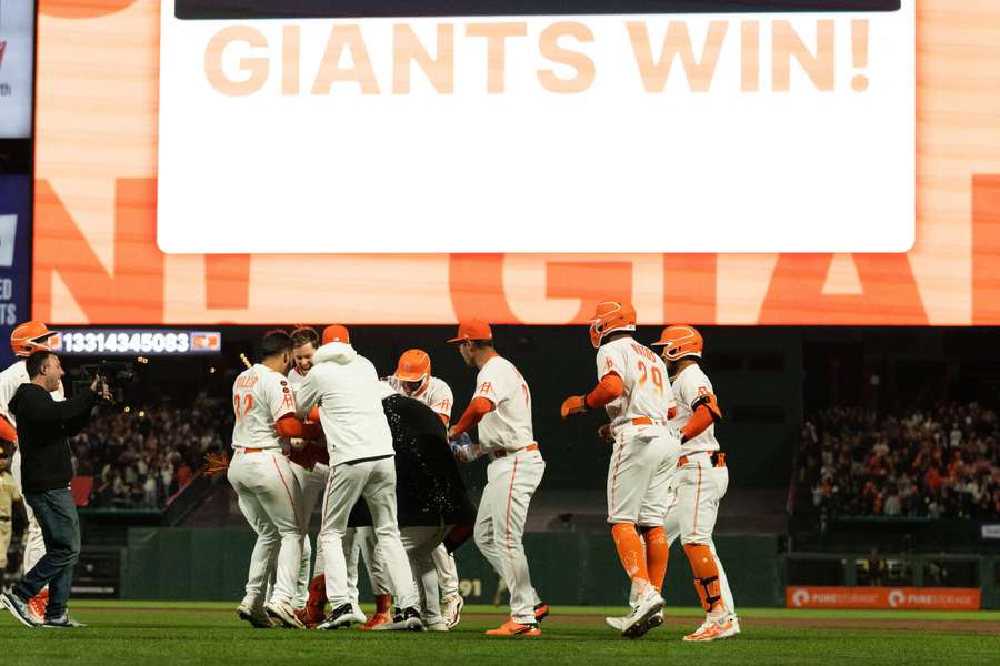 Giants celebrate with designated hitter Joc Pederson after winning the game against Padres