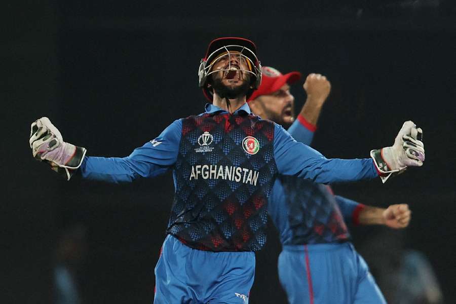 Afghanistan's Ikram Alikhil celebrates after Rashid Khan bowls out England's Mark Wood to win their match at the World Cup