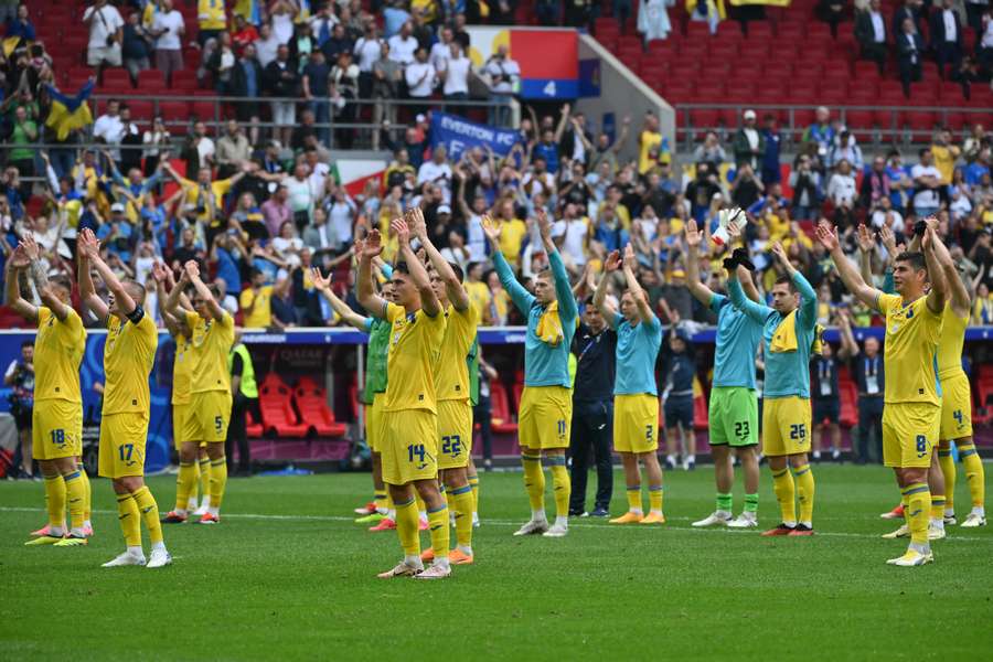 De spelers van Oekraïne vieren de overwinning met de supporters