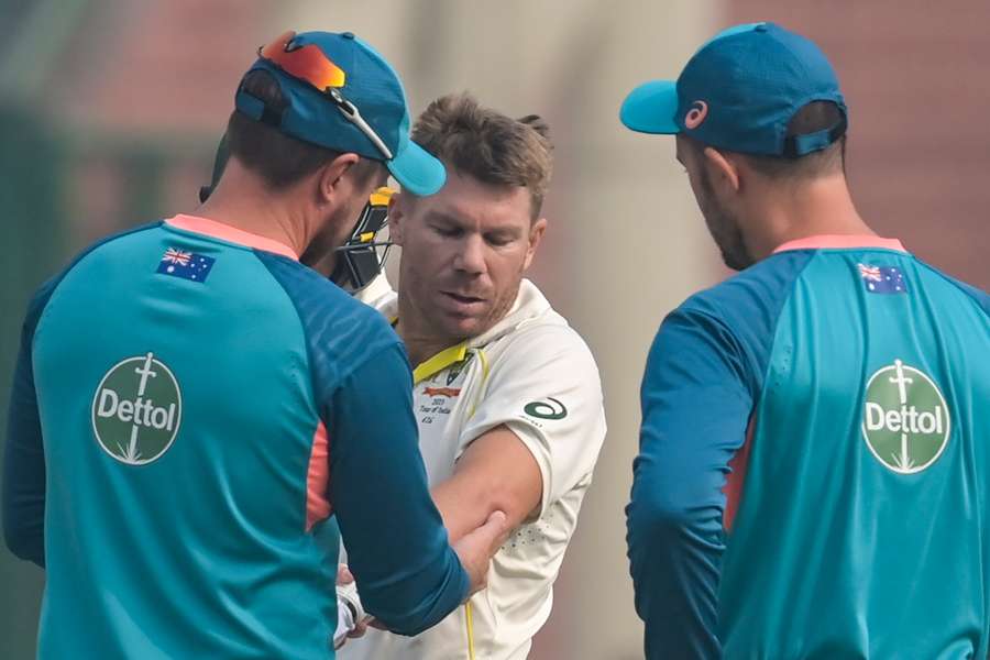 Australia's David Warner gets treatment on his elbow during the opening day of the second Test against India in Delhi