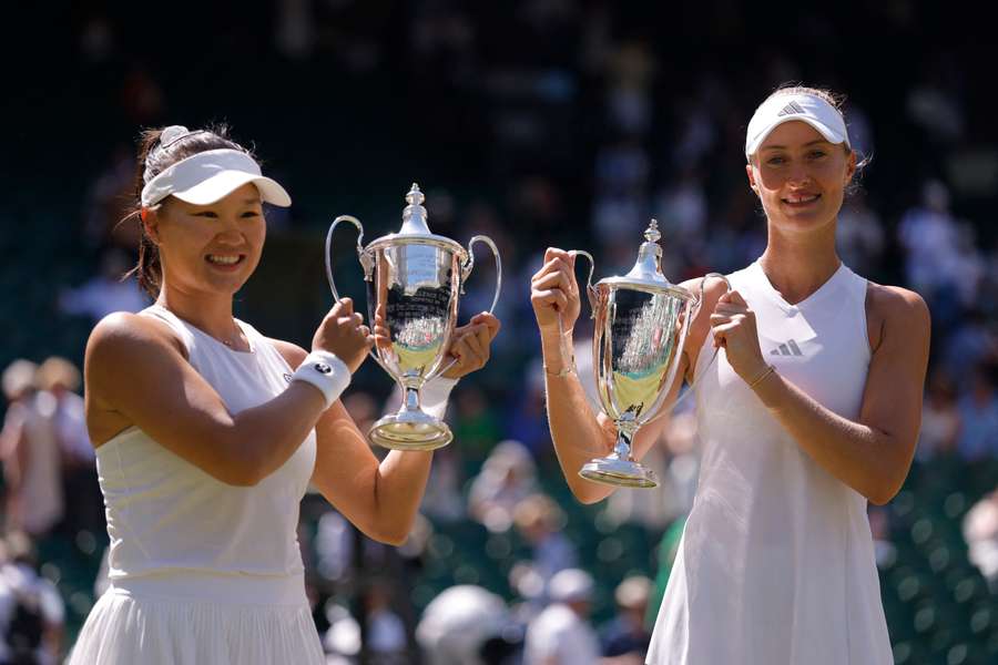 China's Guo Hanyu and France's Kristina Mladenovic celebrate with the trophies after winning the women's doubles final at Wimbledon