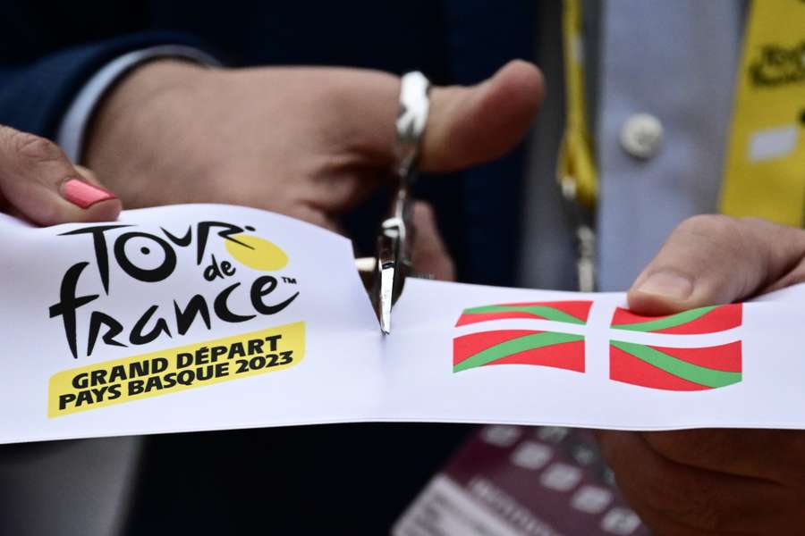 The start line ribbon is cut at the start of the first stage of the 110th edition of the Tour de France