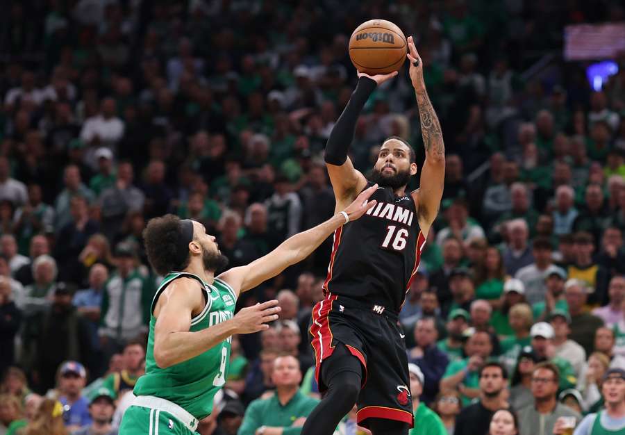 Caleb Martin of the Miami Heat attempts a three point basket against Derrick White of the Boston Celtics