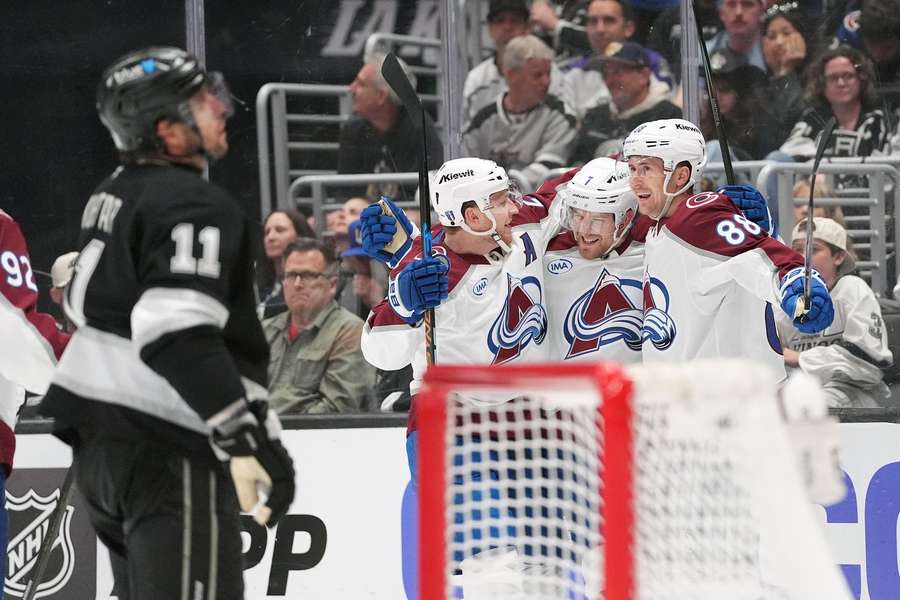 Avalanche players celebrate a goal in Game 4 as Anze Kopitar (left) reacts