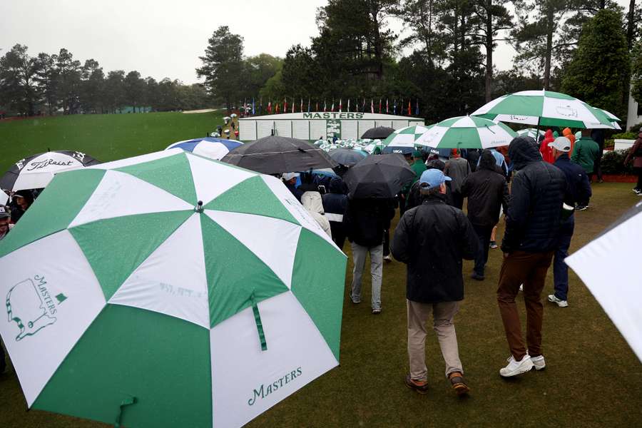 A general view of the leaderboard as patrons look on during the continuation of the weather delayed second round