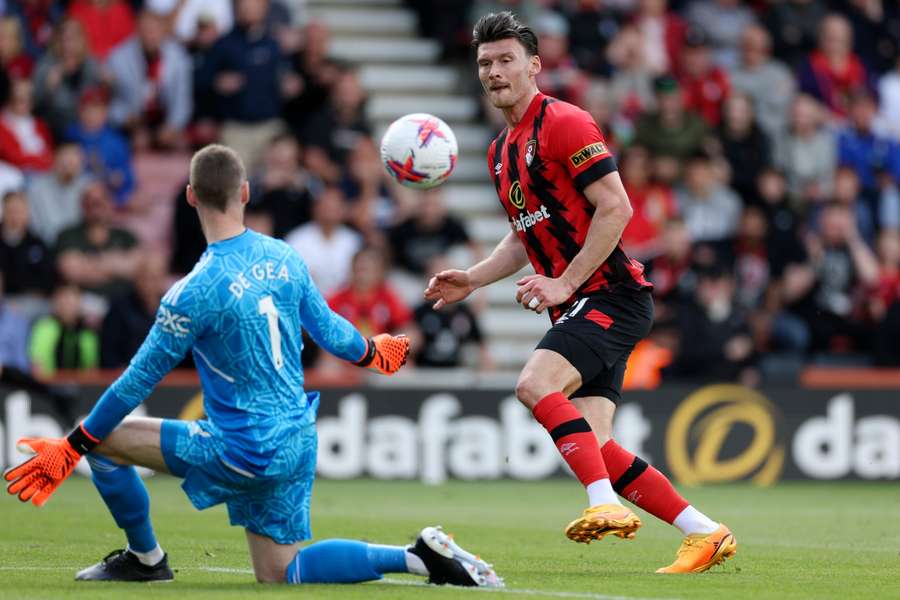 David de Gea (L) blocks a shot on goal by Bournemouth striker Kieffer Moore