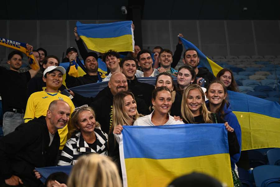 Marta Kostyuk fotografada junto de adeptos ucranianos durante o Open da Austrália