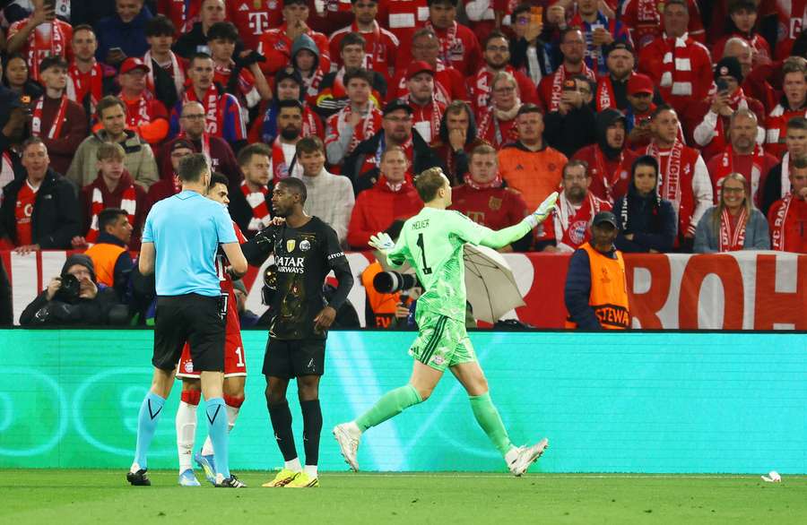 Bayern Munich's Manuel Neuer gestures to fans after objects were thrown onto the pitch