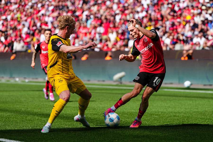 Florian Wirtz of Bayer 04 Leverkusen and Julian Brandt of Borussia Dortmund battle for the ball
