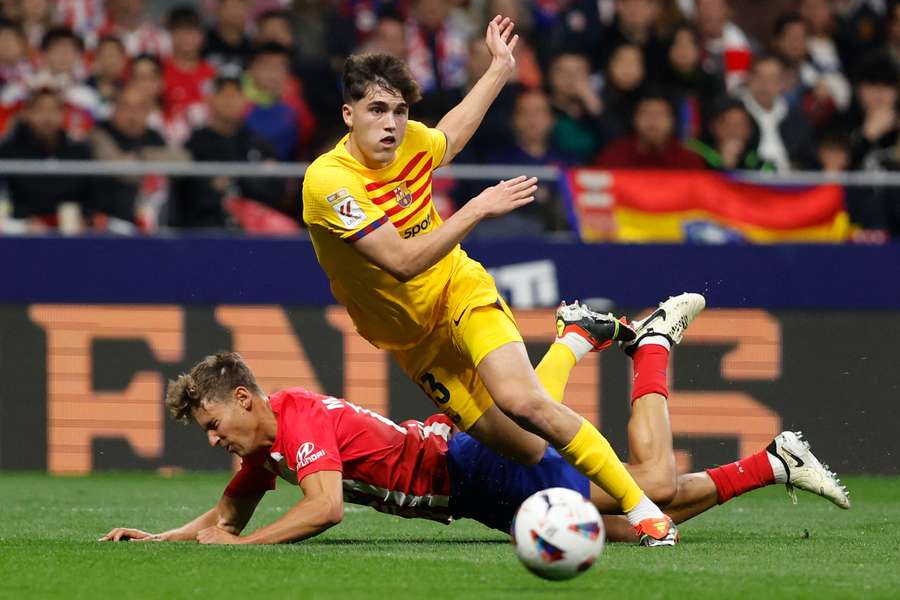 Pau Cubarsí disputa a bola com Marcos Llorente durante o jogo contra o Atlético de Madrid