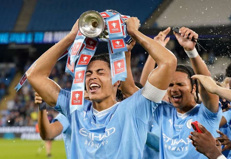 Jahmai Simpson-Pusey of Manchester City holds aloft the cup after beating Leeds during the FA Youth Cup final