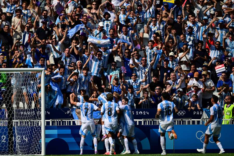 Argentina's midfielder #10 Thiago Almada celebrates with teammates after scoring his team's third goal