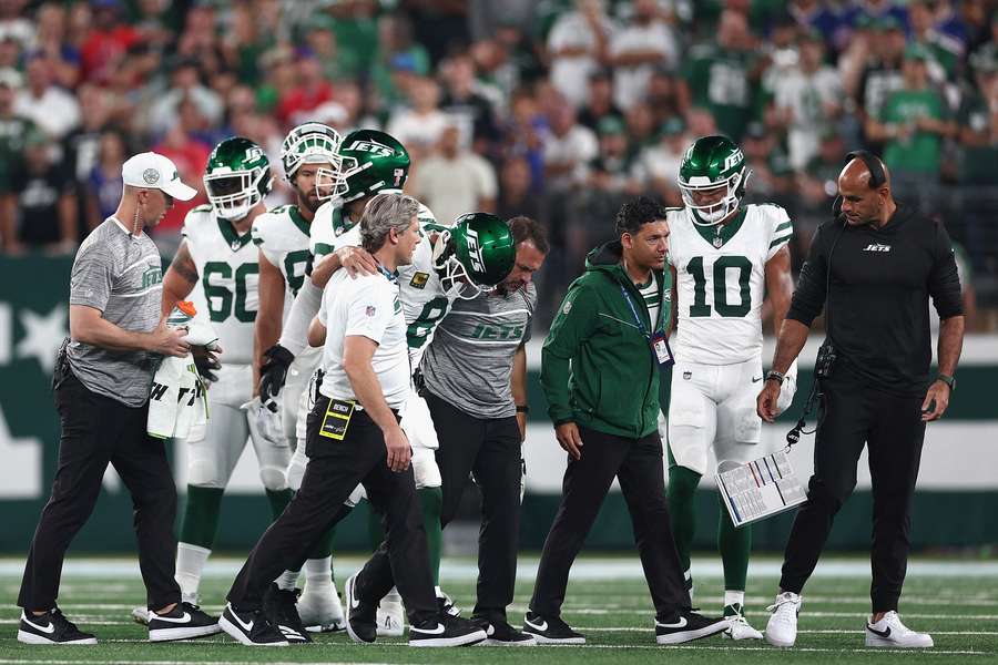 Rodgers (8) is helped off the field