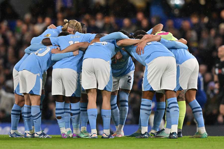 Man City players form a group huddle ahead of kick-off