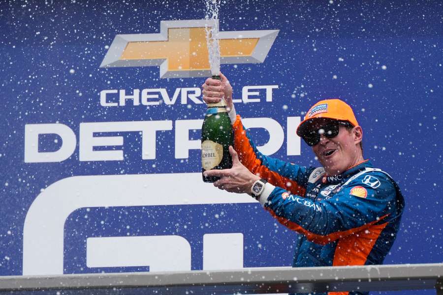 Scott Dixon viert zijn zege op het podium in Detroit