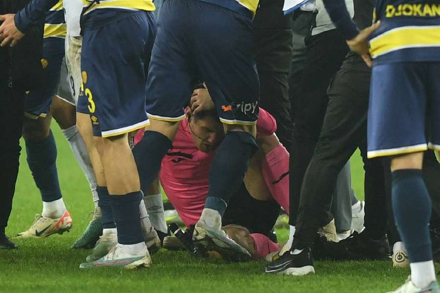 Referee Halil Umut Meler lies on the ground at the end the match