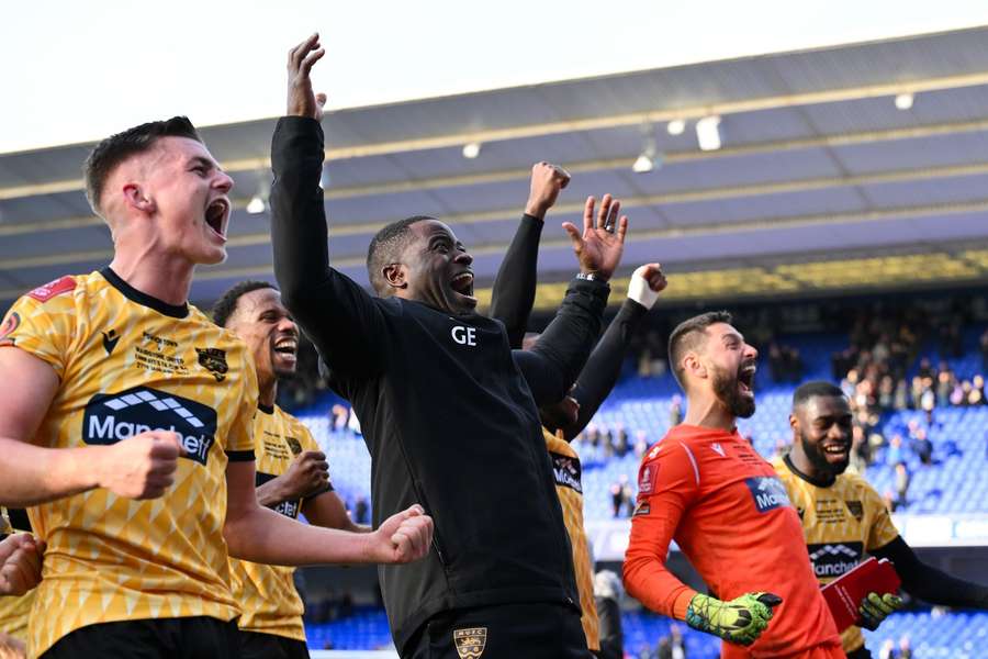 Maidstone United's manager George Elokobi with the players as they celebrate their 2-1 victory