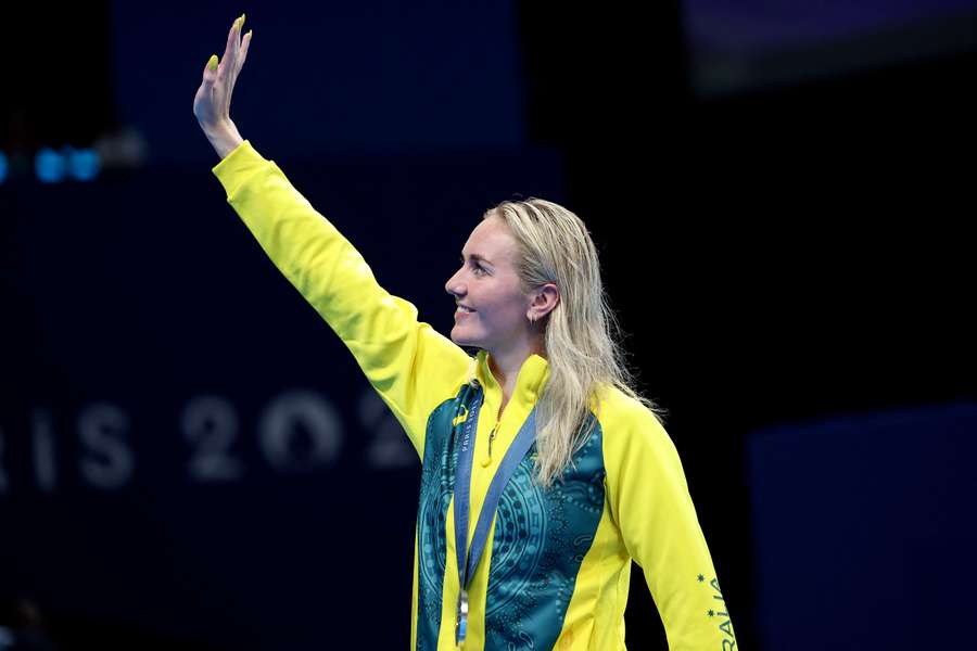 Ariarne Titmus waves to fans during a medal ceremony at the 2024 Paris Olympics.