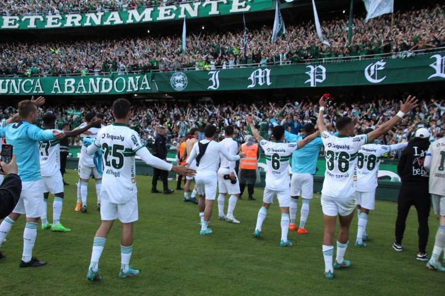 Jogadores do Coritiba comemoram permanência na Série A ao lado da torcida, no Couto Pereira