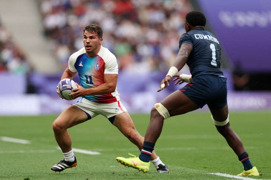 Antoine Dupont of France runs with the ball whilst under pressure from Aaron Cummings of the United States